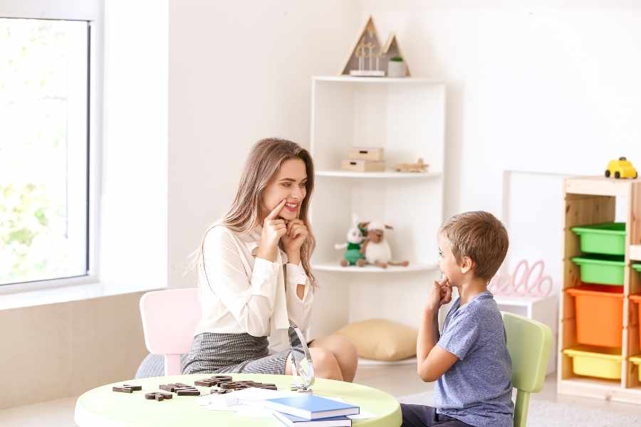 Imagen que muestra una logopeda y un niño con trastornos del habla